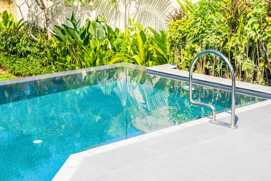 Piscine coque moderne intégrée dans un jardin, idéale pour un projet de piscine extérieure